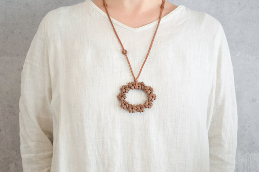 Wild grape pendant with flower ring motif worn on chest / やまぶどうの花リングモチーフのペンダントを身につけている様子