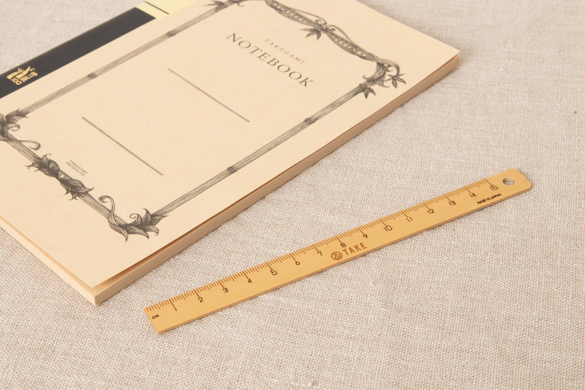 Bamboo ruler and notebook on fabric / 竹のものさしとノートを布の上に置いた様子