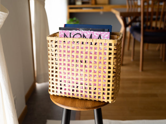 White bamboo magazine rack with magazines on stool / 白竹のマガジンラックに雑誌を入れて椅子の上に置いた様子
