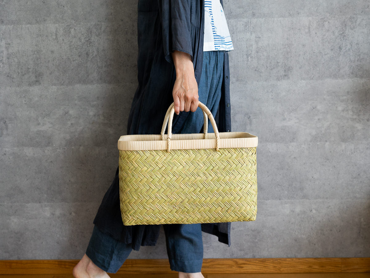 Suzutake bamboo market basket with rattan handle being carried / すず竹の市場かご（籐巻き手）を手に持った様子