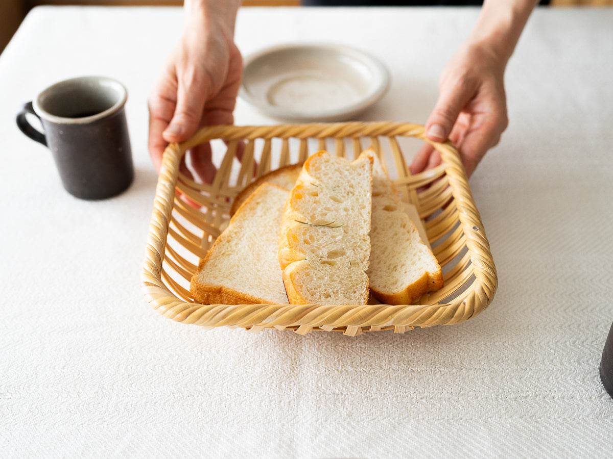 White bamboo “Square Weave” serving tray with bread on table / 白竹の四ツ目編み盛り皿にパンを載せて置いた様子