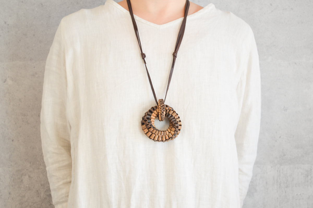 Walnut bark cobblestone ring pendant worn on chest / くるみの石畳リングペンダントを身につけている様子