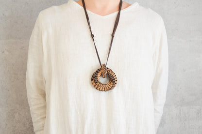 Walnut bark cobblestone ring pendant worn on chest / くるみの石畳リングペンダントを身につけている様子