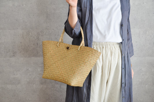 Krajood grass basket bag with closure carried by hand / カチューの留め具付きかごバッグを手に持った様子