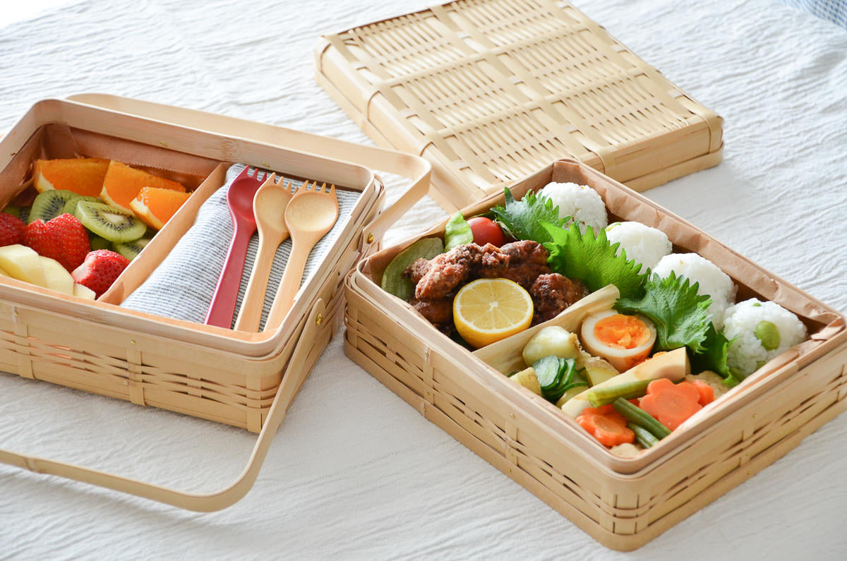 White bamboo two-tier handled lunch baskets with food / 白竹の二段手つき弁当かごに料理が入っている様子