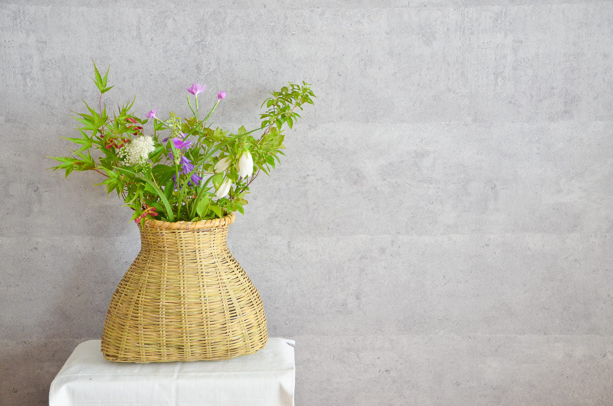 Nemagari bamboo fish basket with greenery and flowers / 根曲竹の魚びくに花材を生けた様子
