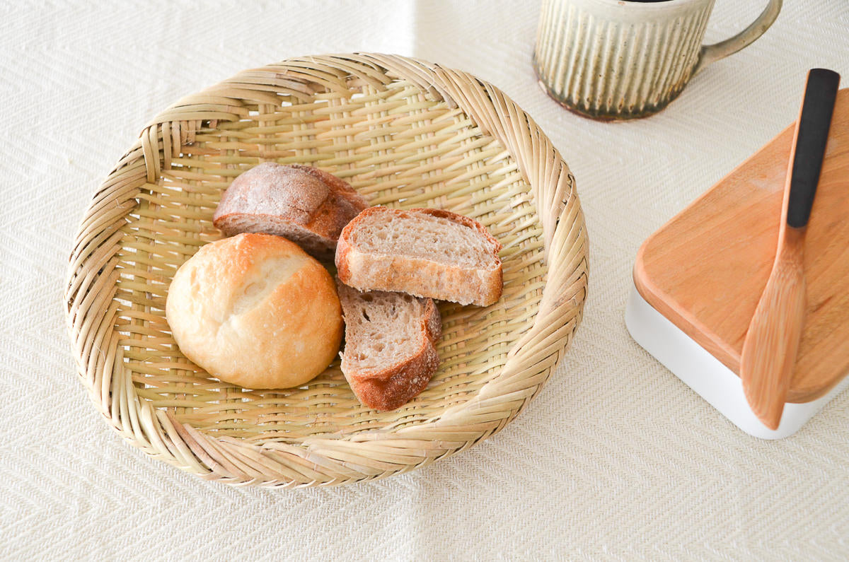 Round suzutake bamboo strainer with bread on a table / すず竹の丸ざるにパンを盛り付けた様子