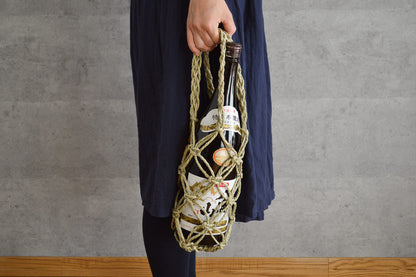 Igusa bottle basket with a bottle held in hand / ボトルが入ったいぐさのびんかごを手に持っている様子