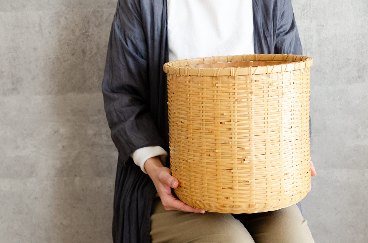 White bamboo cylindrical waste basket being held / 白竹の円筒くずかごを手に持った様子