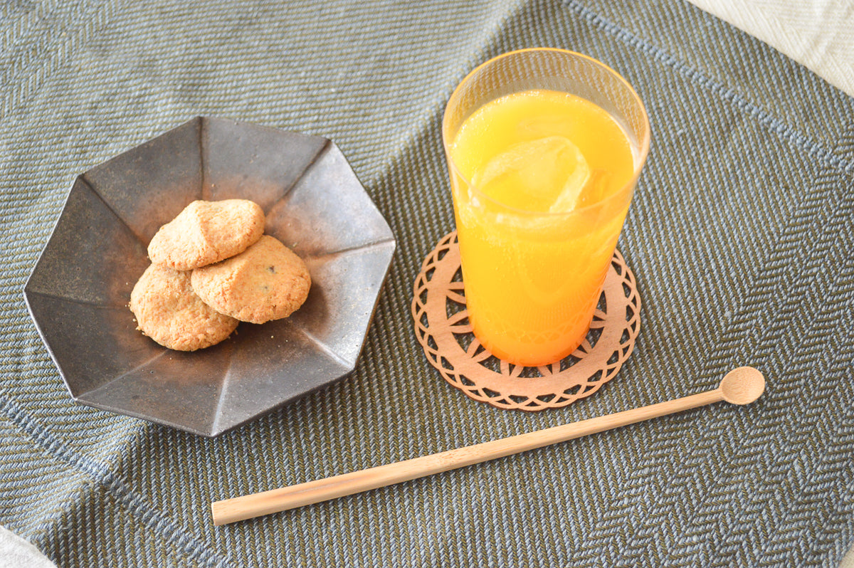 Smoked bamboo stir stick on a tablecloth / 炭竹のマドラーをテーブルクロスの上に置いた様子