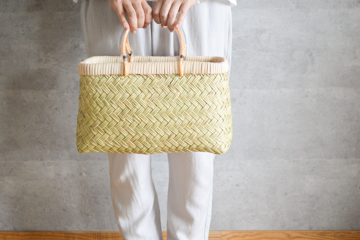 Suzutake bamboo market basket S with pipe handles held in hand / すず竹の市場かご（パイプ手・小）を手に持った様子