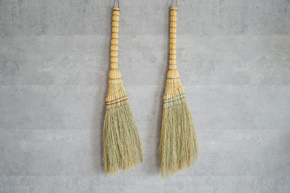 Broomcorn Tomoe brooms hanging on a wall / ホウキモロコシのともえ箒を壁に掛けた様子