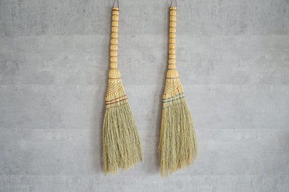 Broomcorn Tomoe brooms hanging on a wall / ホウキモロコシのともえ箒を壁に掛けた様子