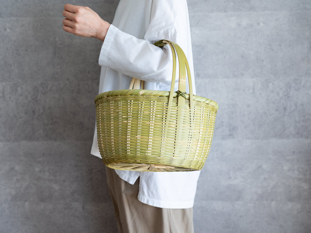 Madake bamboo oval shopping basket held on the arm / 真竹の菊底楕円買い物かごを腕に掛けた様子