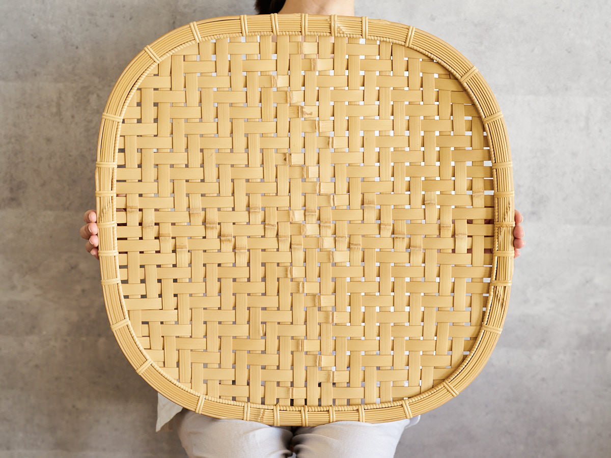 Large white bamboo plate held upright / 白竹の大皿を立てて持っている様子