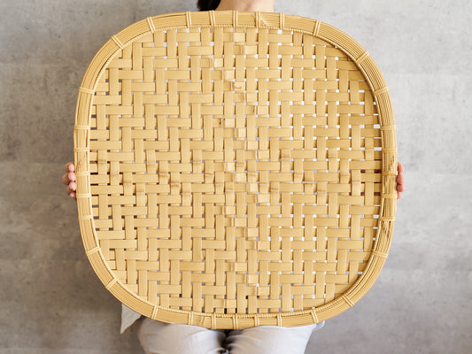 Large white bamboo plate held upright / 白竹の大皿を立てて持っている様子