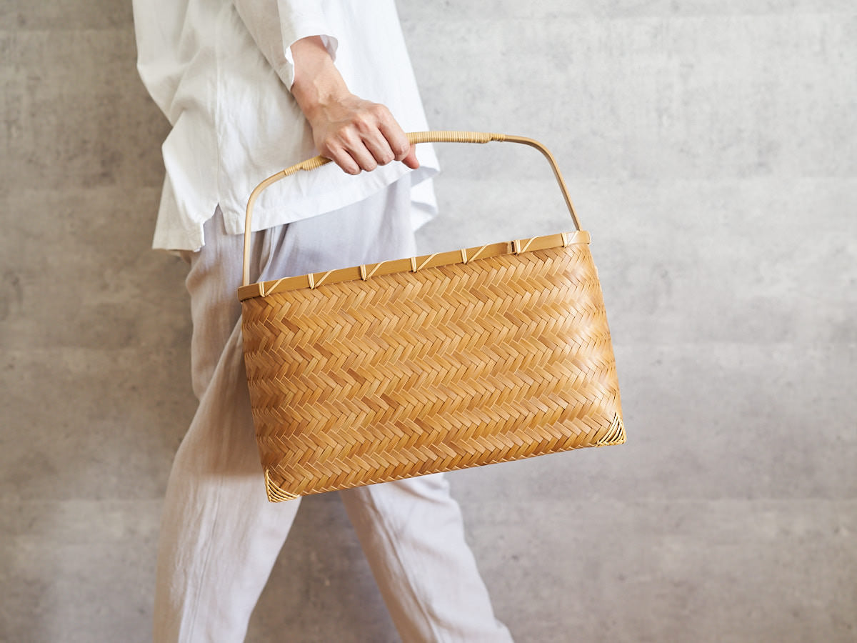 One-handle carbonized bamboo basket bag being held / 炭化竹の一本手のかごバッグを持っている様子