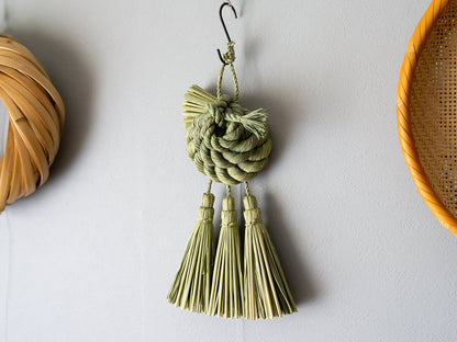 Rice straw shimekazari with spiral knot hanging on a wall / 稲わらのしめかざり（巡り廻る）が壁に掛けられている様子