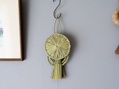 Rice straw shimekazari halo design on a wall / 稲わらのしめかざり（後光）が壁に掛けられている様子