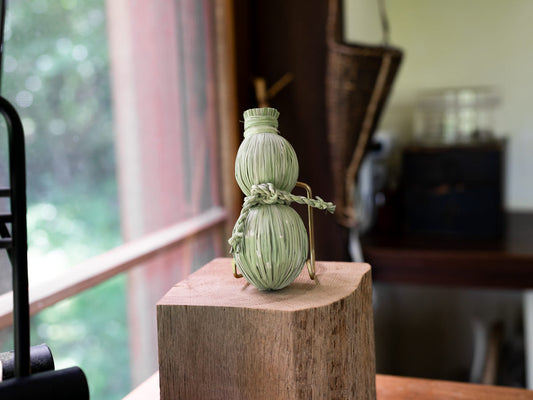 Rice straw shimekazari gourd on a wooden stand / 稲わらのしめかざり（瓢）を台の上に置いた様子