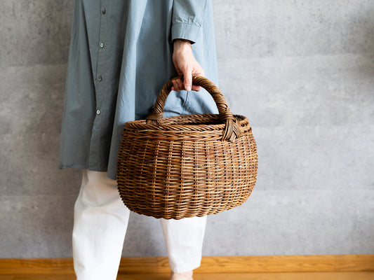 Akebi round basket with handle being carried by hand / あけびの丸バスケット（一本手）を手に持っている様子