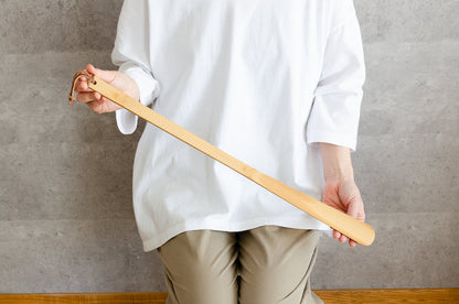 Smoked bamboo shoe horn held in hand / 炭竹の靴べらを手に持っている様子