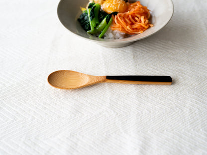 Smoked bamboo curry spoon on a tablecloth / 炭竹のカレースプーンをテーブルクロスの上に置いた様子