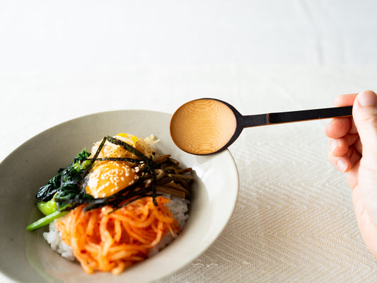 Smoked bamboo long spoon held in hand / 炭竹のスッカラを手に持っている様子