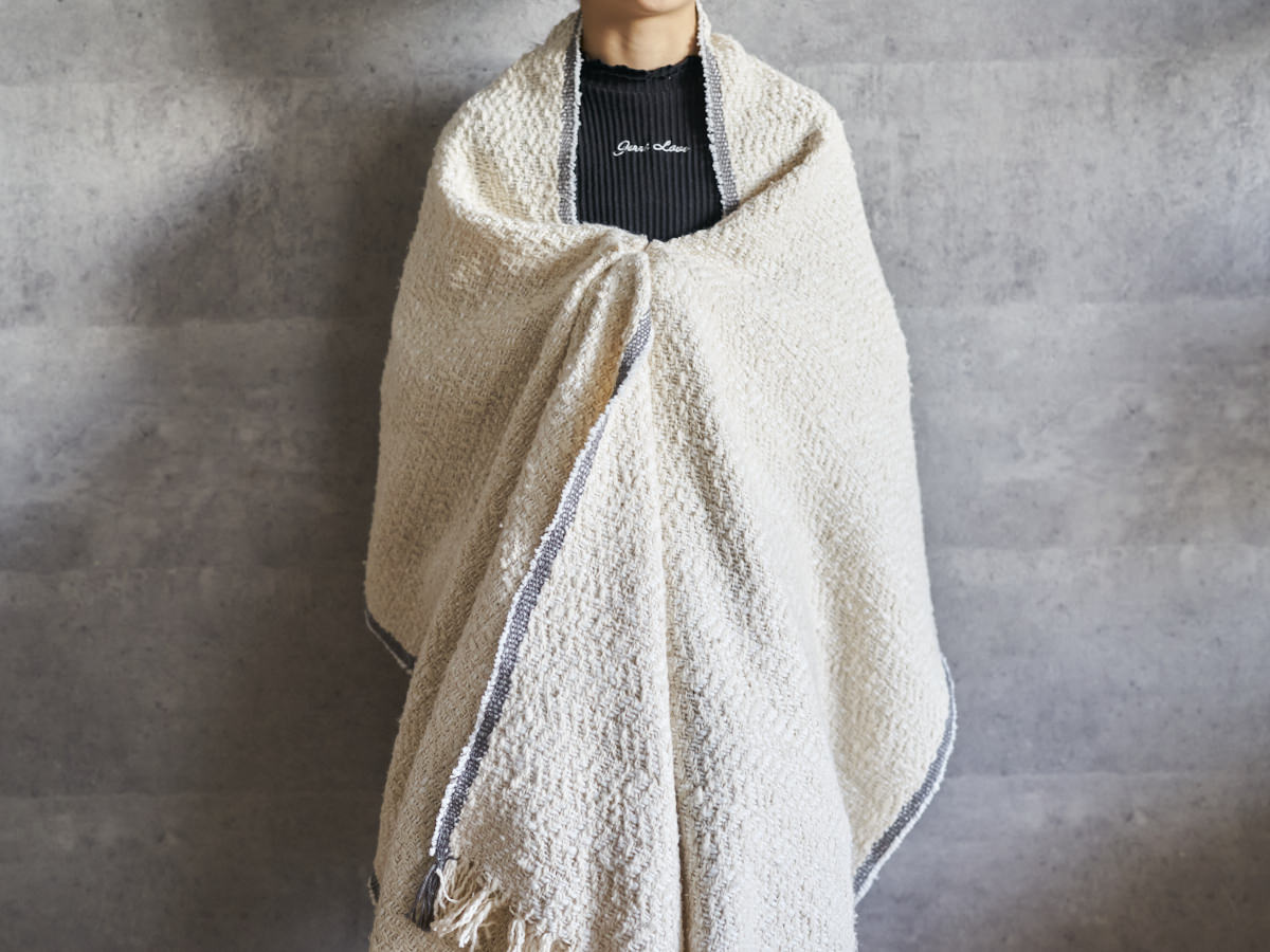 Gara-bou spun cotton ivory herringbone stole draped over shoulders / ガラ紡コットンのアイボリーのヘリンボーン柄ストールを肩に羽織った様子