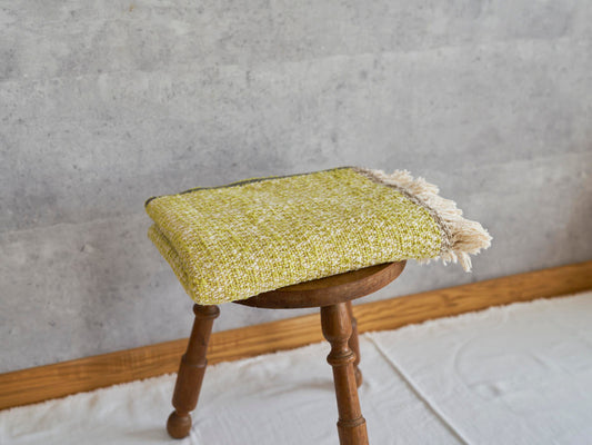 Woven cotton stole placed on a wooden stool / コットンのガラ紡ストールをスツールに置いた様子