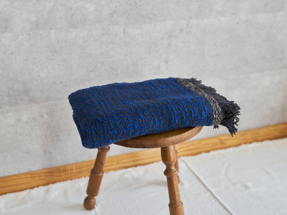 Woven cotton stole placed on a wooden stool / コットンのガラ紡ストールをスツールに置いた様子
