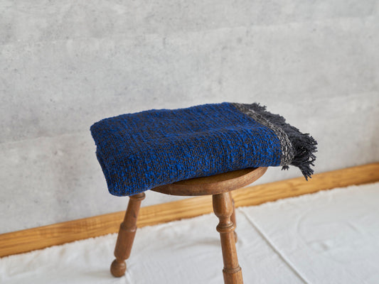 Woven cotton stole placed on a wooden stool / コットンのガラ紡ストールをスツールに置いた様子