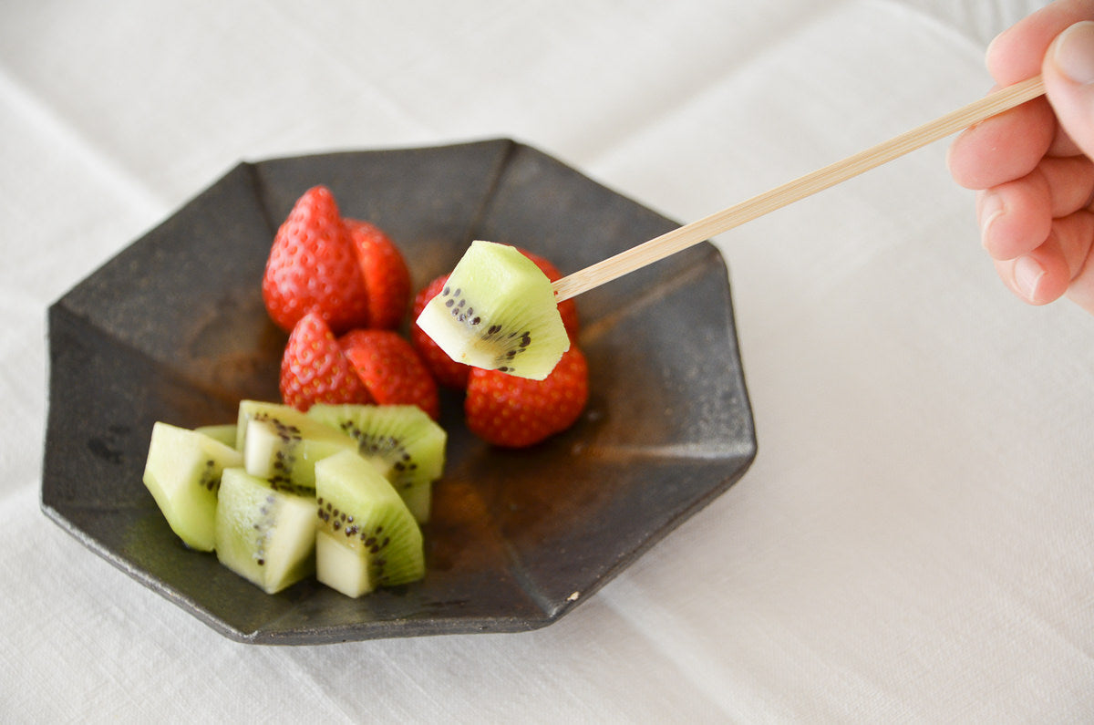 White bamboo pick with fruit / 白竹ピックでフルーツを取る様子