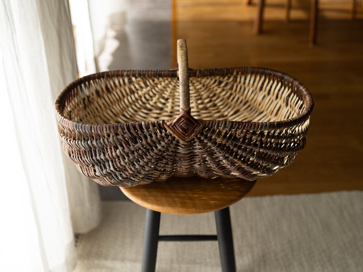 Willow and hazel outdoor basket “Wild” placed on a stool / やなぎとヘーゼルのアウトドアバスケット“Wild”をスツールの上に置いた様子