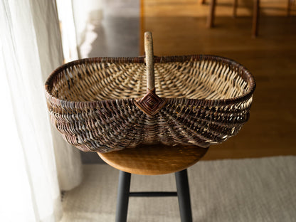 Willow and hazel outdoor basket “Wild” placed on a stool / やなぎとヘーゼルのアウトドアバスケット“Wild”をスツールの上に置いた様子
