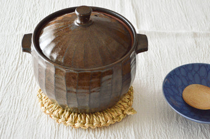 Rice-straw trivet with a clay pot placed on top / わらの釜敷きの上に土鍋を置いた様子