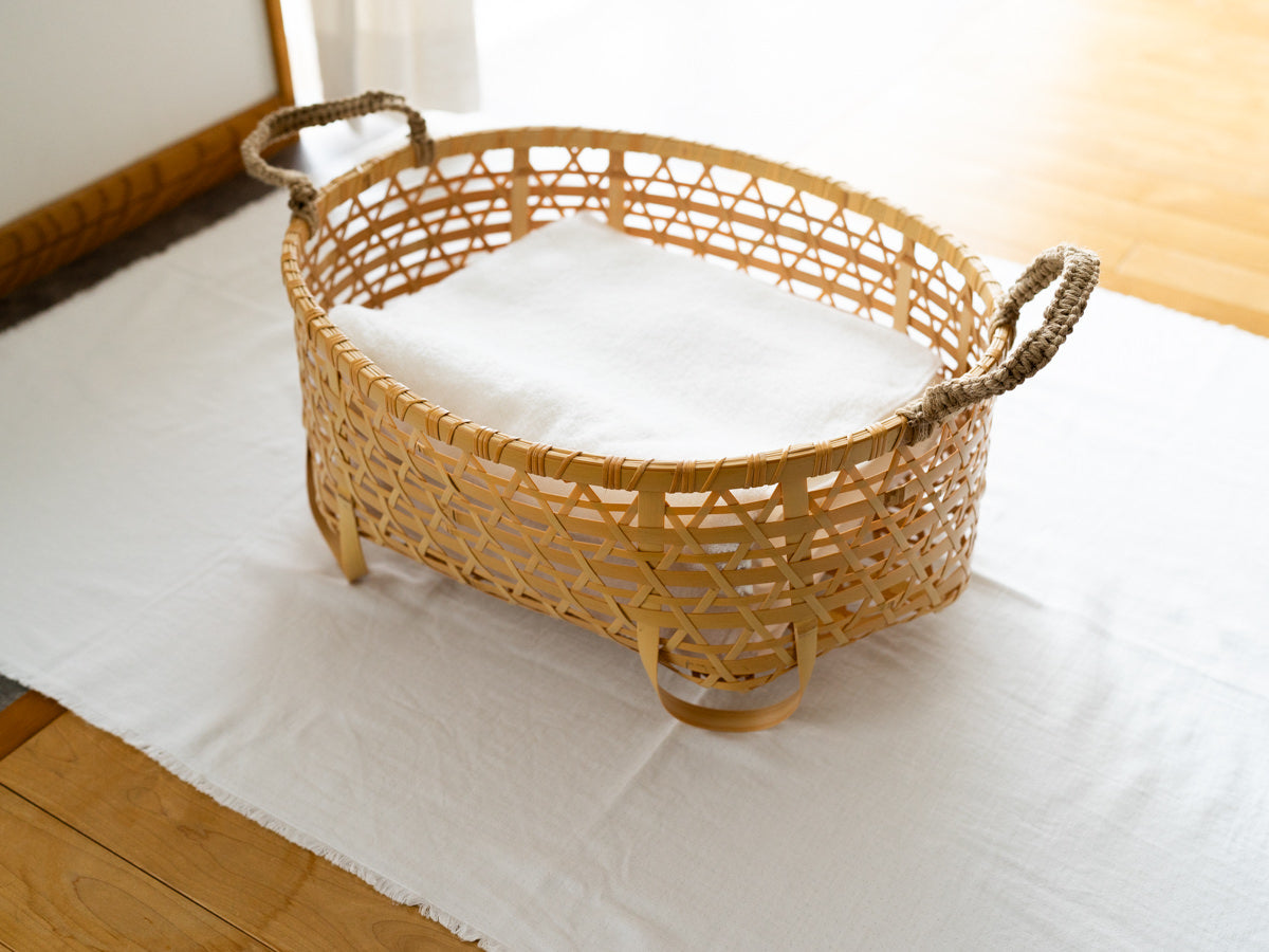White bamboo oval basket with cloth items / 白竹のオーバルバスケットに布物が入っている様子