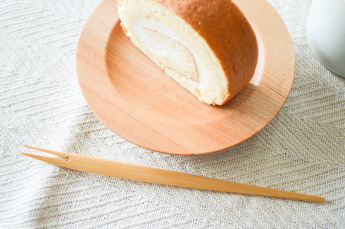 Moso bamboo fish fork beside dessert plate / 孟宗竹のお魚フォークがデザート皿のそばに置かれている様子